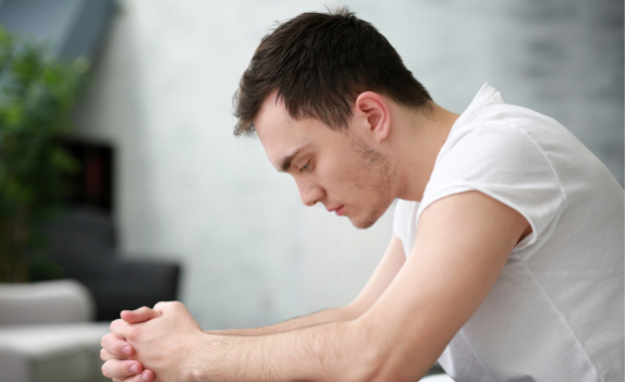 man sitting down staring at the ground in need of Individual Substance Abuse Counseling