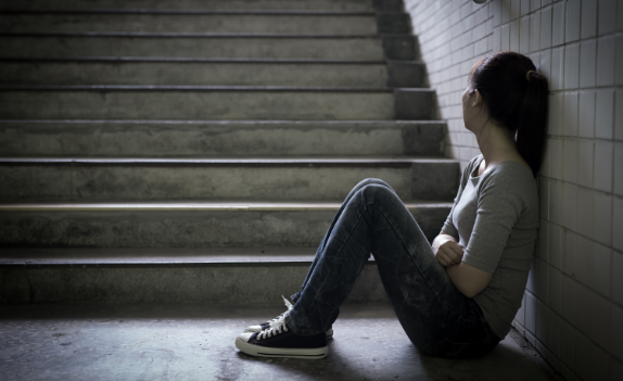 girl sitting next to stairs looking in the opposite direction of the camera in need of Outpatient Substance Abuse Treatment