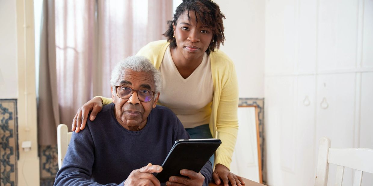 young person helping older gentleman on a tablet to find Elderly Substance Abuse Treatment